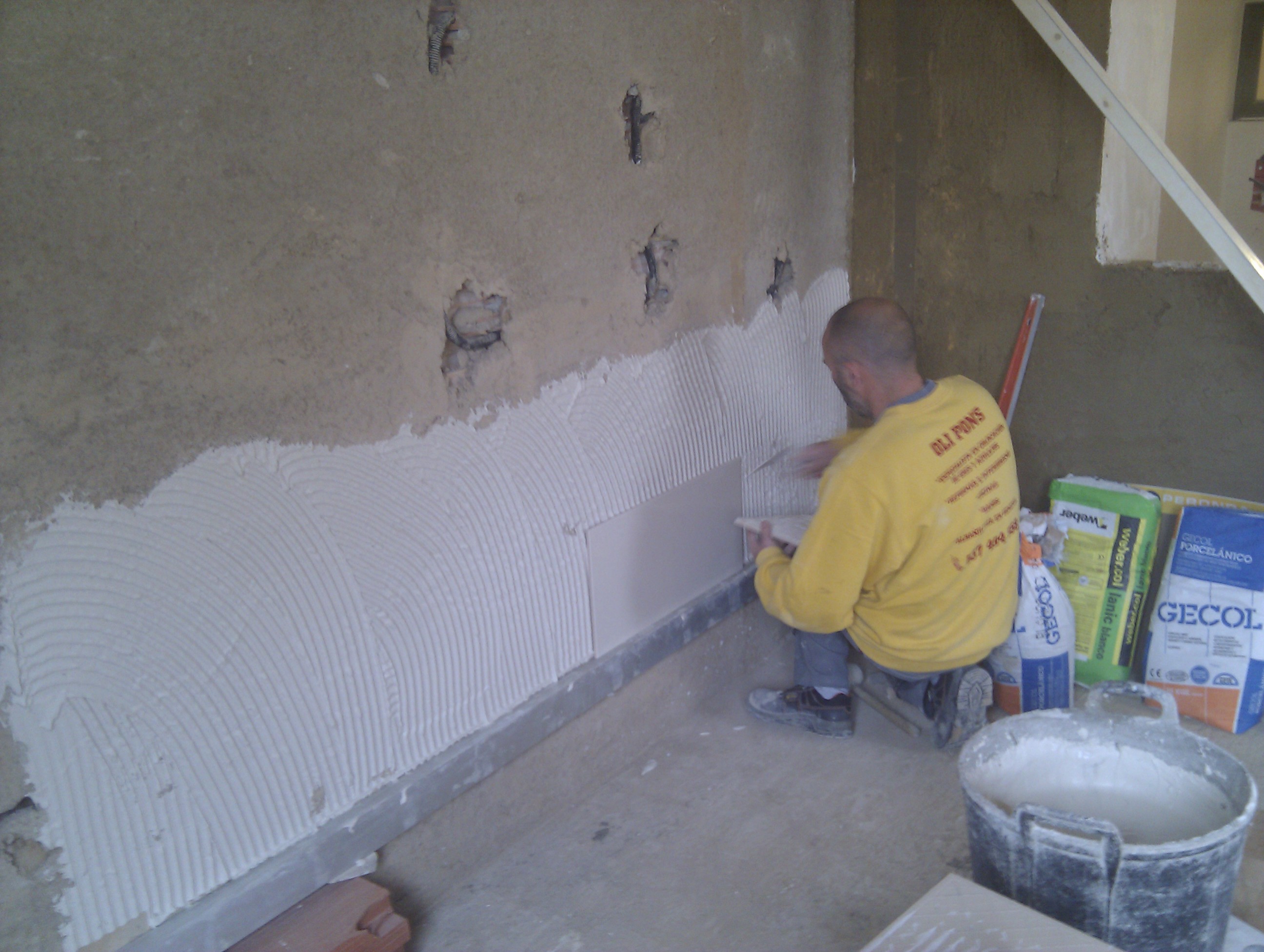 Una vez hecho el "enfoscado maestreado" a regle con mortero-cemento, se procede a la colocación de azulejos.